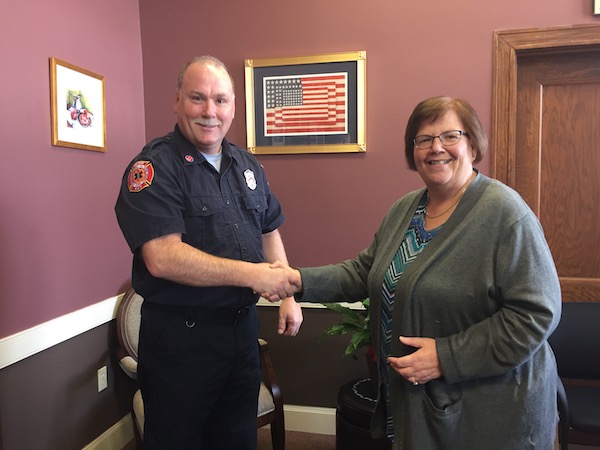 Photo of Fire Captain Ed Collina shaking hands with Mayor Gail Infurna