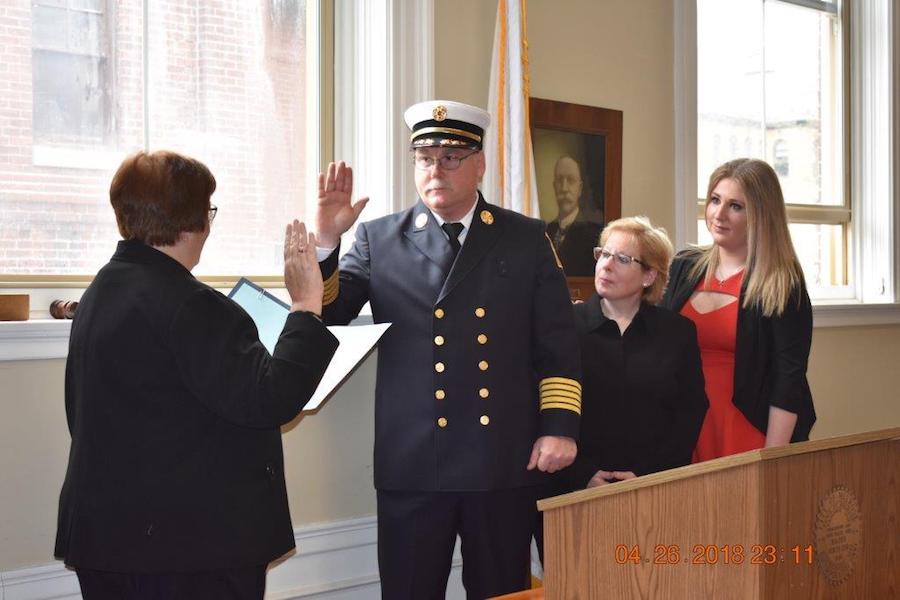Mayor Infurna swears in Fire Chief Ed Collina as his wife, Cindy, and his daughter, Nicole, look on.
