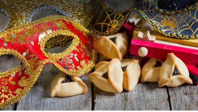 Photo of carnival mask, hamentaschen, and wooden toy