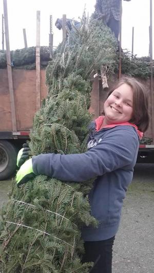 Photo of girl holding a Christmas tree