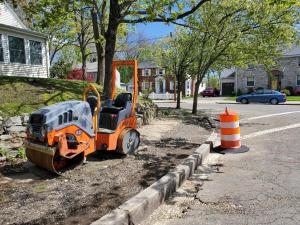 Construction equipment on residential sidewalk, getting ready for repavement