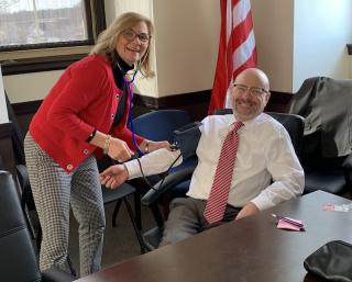 Photo of Karen Cronin taking Mayor Brodeur's blood pressure